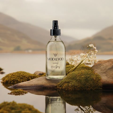 Hair spray bottle on a rock with a scenic background of mountains and a loch