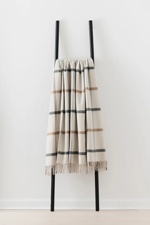 Milton merino lambswool blanket in Pebble draped over a ladder, made in Scotland