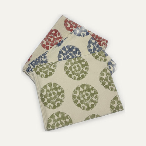 Three Rebecca Plater organic cotton tea towels in red, blue and moss green, Machair Clock design